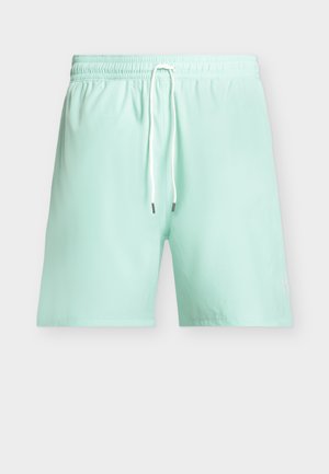 Lyse turkise badeshorts med elastisk talje og hvid snor, vist forfra mod en ensfarvet baggrund.