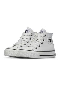 Białe wysokie trampki wykonane z gładkiego materiału, z czarnymi akcentami, gumową podeszwą z teksturowanym wzorem i metalowymi oczkami.