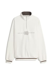 Bela zip-up jopica z visokim ovratnikom, ki ima rjave detajle na ovratniku in robu, ter natisnjen napis "BOLD" na sredini.