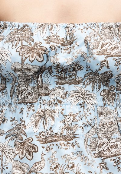 Tissu bleu clair à épaules dénudées avec un imprimé tropical détaillé marron comprenant des palmiers, des fleurs et des oiseaux.