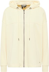 Hanorac crem cu fermoar, cu glugă, realizat dintr-un material texturat, având șnururi, fermoar frontal și manșete cu elastic.