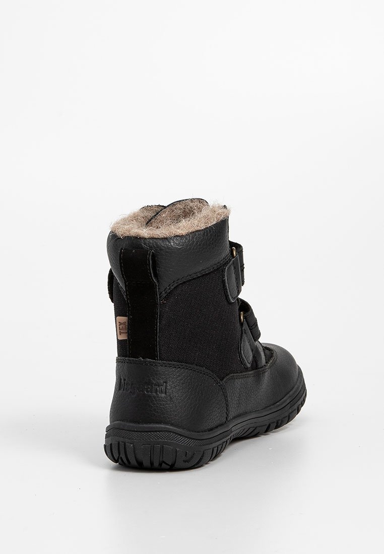 Schwarze Knöchelstiefel aus einer Kombination von Leder und Textil, mit einem flauschigen Futter am Kragen, zwei verstellbaren Riemen und einer strukturierten Gummisohle.