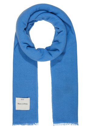 Weicher, blauer Wollschal mit fransigen Rändern, zu einer Schlaufe gefaltet, mit einem weißen rechteckigen Etikett mit Markenaufdruck.