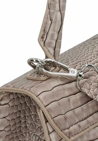 Bolso beige con estampado de cocodrilo y superficie texturizada, con accesorios de plata y cierre de clip. Acentuado con un ribete en color crema.