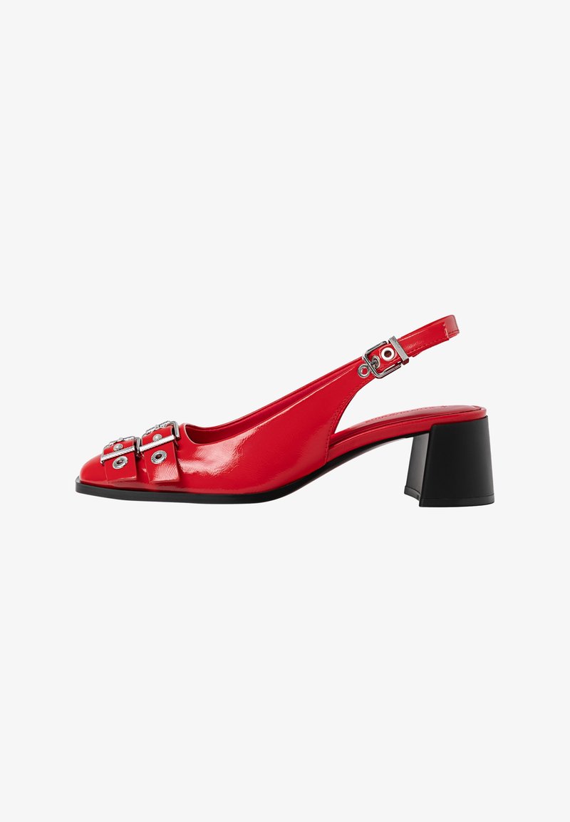 Chaussure slingback en cuir verni rouge avec talon bloc noir, deux boucles avant avec œillets argentés, et boucle de bride de cheville réglable.