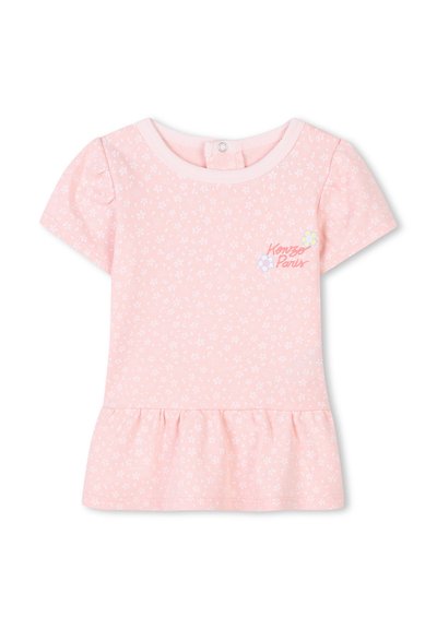 Robe rose à manches courtes en coton, avec un peplum évasé, un motif floral blanc, et un logo brodé de plusieurs couleurs sur la poitrine.