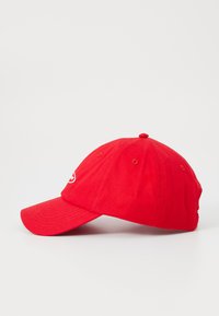 Rode katoenen honkbalcap met een gebogen rand, zespanelen ontwerp en een geborduurd logo aan de voorkant. Beschikt over ventilatiegaten.
