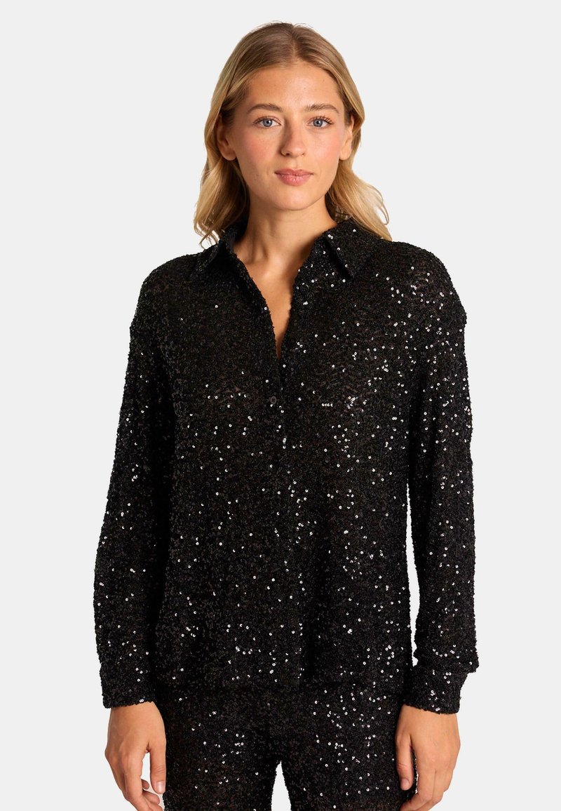Camisa negra de botones con lentejuelas, de manga larga y con cuello, que presenta una superficie texturizada y detalles brillantes por todo su diseño.
