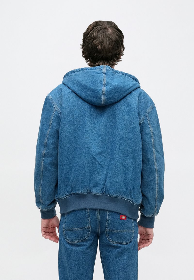 Jeans-Hoodie in Hellblau mit Kordelzugkapuze, elastischen Bündchen und einem gerippten Saum, versehen mit einer dezenten, ausgewaschenen Textur und Nahtdetails.