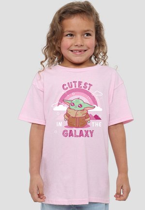 Rosa Baumwoll-T-Shirt mit einem Grafikmotiv eines grünen Charakters mit großen Ohren und ausdrucksvollen Augen, darüber der Text "ZUCKERIGST IM UNIVERSUM."