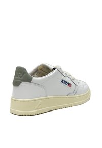 Sneaker in pelle bianca con copri tallone grigio, suola testurizzata e marchio "AUTRY" in blu/rosso. Presenta perforazioni sulla punta e un design classico.