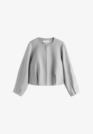 Grå kort jakke med en glat tekstur, rund halsudskæring, lynlås foran og raglanærmer. Har detaljer med rynkede folder ved kanten.