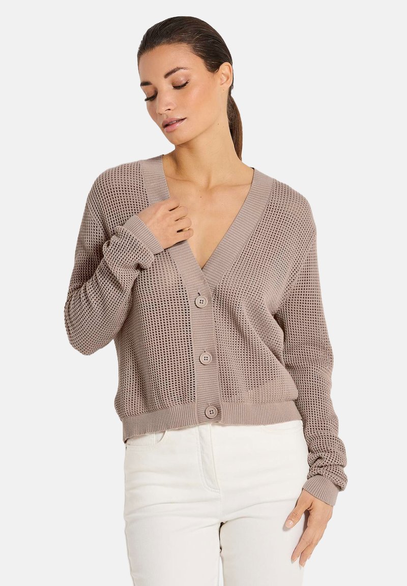 Helle beige Strickjacke mit V-Ausschnitt, langen Ärmeln und fünf Knöpfen. Das strukturierte Muster verleiht dem Design visuelles Interesse.