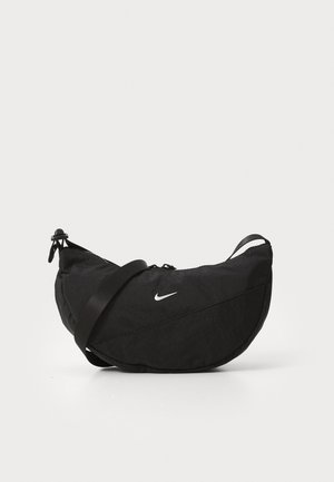 Bolso de hombro negro en forma de media luna de Nike con correa ajustable y logo blanco Swoosh en el frente sobre un fondo claro y liso.