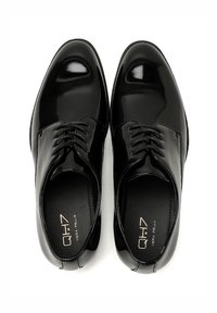 Zapatos de vestir de charol negro con un acabado brillante, punta redondeada, diseño de encaje de seis ojetes y plantillas de cuero mate contrastante.