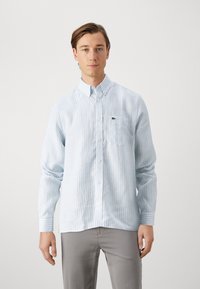 Hellblau gestreiftes Shirt aus weichem Stoff, mit einem Button-Down-Kragen, langen Ärmeln und einer Brusttasche mit kleinem Logo.