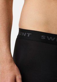Czarne bokserki z elastycznej tkaniny, z szerokim pasem w talii z napisem "SWUNT" w kolorze szarym. Gładka tekstura i dopasowany krój.