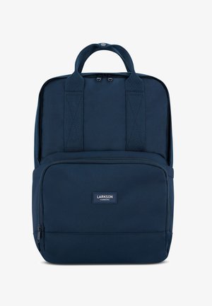 Granatowy plecak z materiału, z dwoma uchwytami u góry, regulowanymi szelkami, kieszenią zapinaną na zamek z przodu oraz małą naszywką z logo na przodzie.