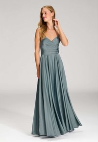 Langes, türkisfarbenes Abendkleid mit tailliertem Oberteil, V-Ausschnitt und schwingendem Rock. Hergestellt aus glattem Stoff, mit dünnen Trägern und gerafftem Bund.