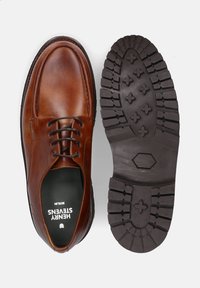 Braune Lederschuhe mit rundem Zehenbereich, Schnürdesign und einer strukturierten Gummisohle mit Profilmuster für Traktion.