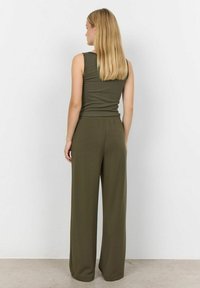 Olivgrünes Tanktop kombiniert mit lockeren, weit geschnittenen Hosen, beide aus weichem Stoff und mit einem einfachen, leichten Design.
