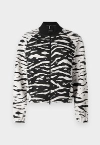 Veste bomber à imprimé zèbre noir et blanc avec fermeture éclair à l'avant, col et poignets côtelés, confectionnée dans un tissu lisse.