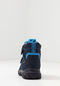 Stivale da trekking blu navy con cinturini in velcro, parte superiore in suede e tessuto, dettagli in blu chiaro, colletto imbottito e suola in gomma con presa testurizzata.