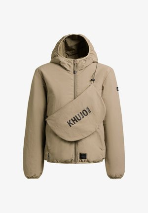 Bež jakna s kapuljačom i prednjim patentnim zatvaračem te pripadajućom torbom preko ramena s crnim logotipom "KHUJO 2001". Elastični rubovi na rukavima i donjem dijelu.