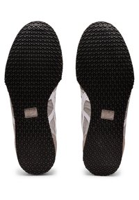 Podešve bot jsou vyrobeny z černé gumy s texturovaným vzorem pro lepší přilnavost, doplněné světle šedými a béžovými svrchními materiály s detailem brandu.