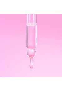 Szklana pipeta wypełniona jasno-różowym płynem, z przezroczystą, wydłużoną bańką i ostrym końcem. Tło to delikatny, różowy gradient.