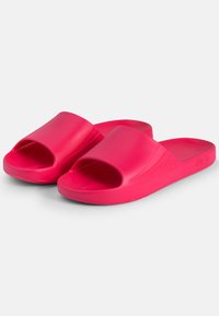Lyserøde slid-sandaler lavet af glat gummi, med et åbent tådesign og tekstureret indersål for bedre greb. Ingen synlig branding.