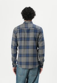 Hemd in blau-beige Karomuster mit langen Ärmeln, einem Kragen und geknöpften Manschetten. Der Stoff wirkt weich mit einer glatten Textur.