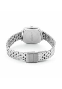 Montre en acier inoxydable argenté avec un boîtier carré, un bracelet à maillons en métal et une fermeture dissimulée. Le dos gravé comprend des informations sur la marque et le modèle.