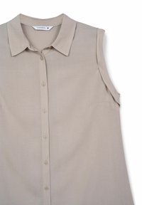 Blusa senza maniche beige con colletto, chiusura frontale a bottoni e tessuto morbido. Presenta una leggera lucentezza e dettagli sulle spalle laterali.