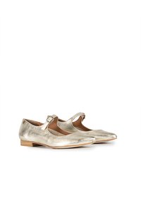 Zapatos planos metálicos de oro con correa tipo Mary Jane, puntera redondeada y un bajo tacón de madera. Superficie texturizada con un interior suave y forrado.