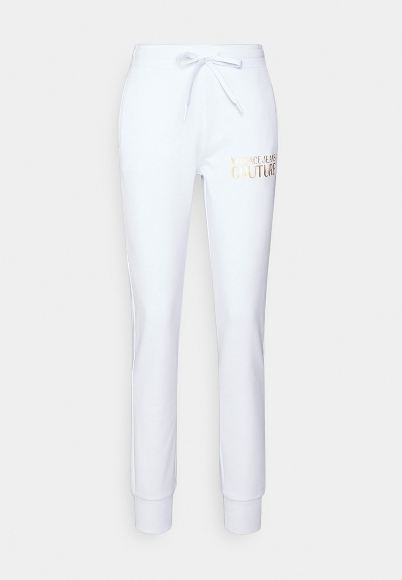 Bílé tepláky vyrobené z měkkého materiálu, se stahovací šňůrkou v pase a žebrovanými manžetami. Na boku je vytištěno logo "Versace Jeans Couture" ve zlaté barvě.