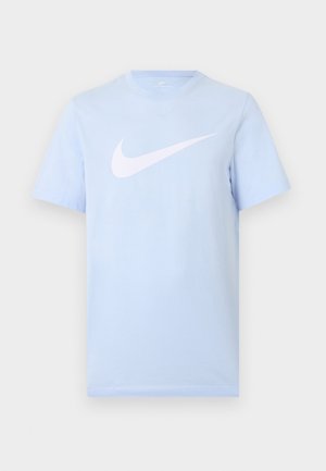 Jasnoniebieski T-shirt z krótkim rękawem, z dużym białym logo Nike w kształcie łyżwy na środku przodu na jednolitym tle.
