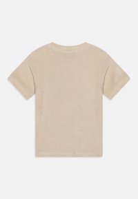 Μπεζ κοντομάνικο μπλουζάκι φτιαγμένο από μαλακό, υφασμένο ύφασμα. Απλή στρογγυλή λαιμόκοψη με καθαρή ραφή και μινιμαλιστικό σχεδιασμό.