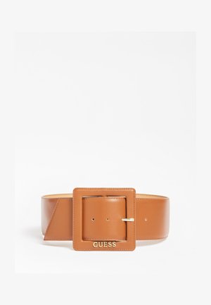 Large ceinture en cuir fauve avec une grande boucle carrée affichant le logo doré "GUESS" sur fond blanc.