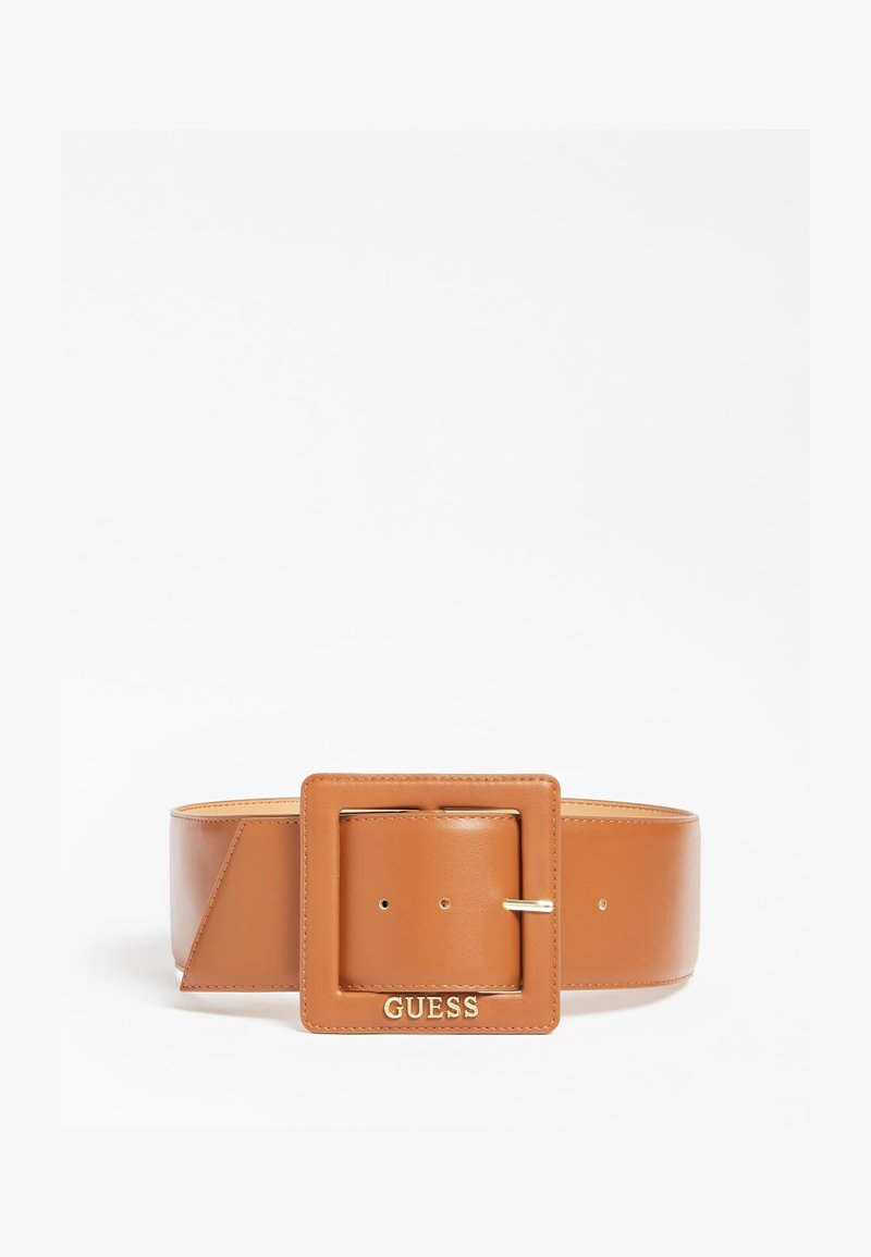 Large ceinture en cuir fauve avec une grande boucle carrée affichant le logo doré "GUESS" sur fond blanc.