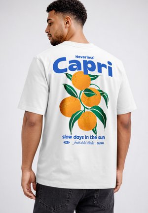 Mann, der von hinten zu sehen ist, trägt ein weißes T-Shirt mit blauem Schriftzug "Capri" und einem illustrierten Orangenzweig auf dem Rücken.