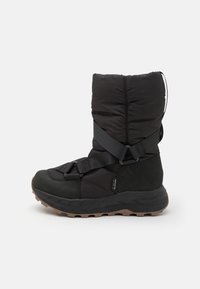 Svart ankelstøvel med polstret overdel, elastiske stropper og en teksturert gummisåle. Har en glatt tåhette og et fleksibelt design.
