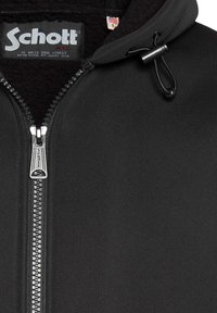 Zwarte hoodie met rits en een zachte fleece voering aan de binnenkant, voorzien van een metalen rits en verstelbare trekkoord bij de capuchon. Schott-logo zichtbaar.