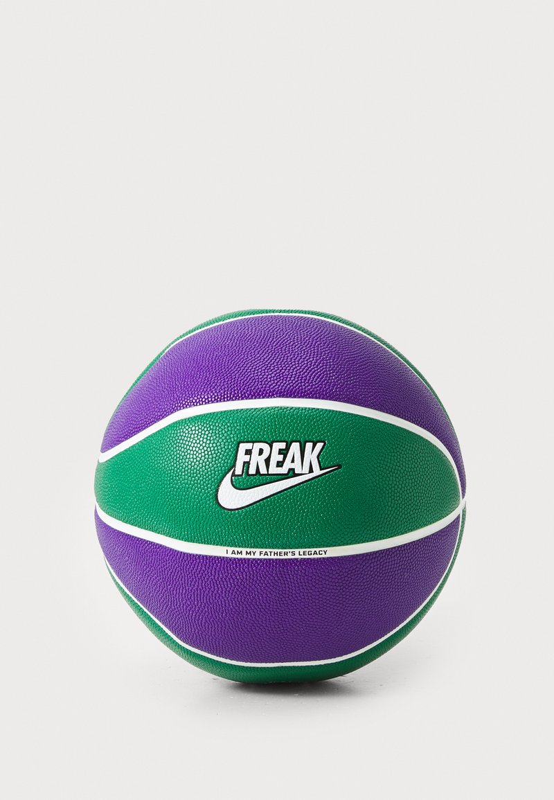 Un ballon de basket au design violet et vert avec une surface texturée, des accents blancs et le logo Nike. Le texte indique "FREAK" et "JE SUIS L'HÉRITAGE DE MON PÈRE."