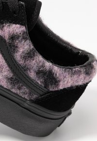 Schwarzer Plateau-Sneaker mit einem strukturierten Stoffoberteil in Schattierungen von Lila und Schwarz, mit glattem Lederfinish und robuster Gummisohle.