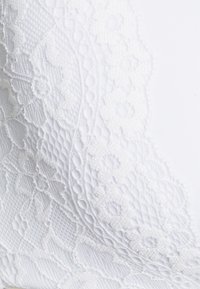 Witte kantstof met ingewikkelde bloem- en geometrische patronen, met textuurdetails en een gladde onderlaag.