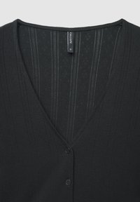 Cardigan noir en tissu tricoté texturé, présentant un col en V, des rayures verticales et trois boutons noirs à l'avant. Étiquette de la marque visible.