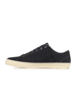 Sneaker basse in suede nero con lacci neri e suola in gomma beige, mostrata di profilo su sfondo bianco.