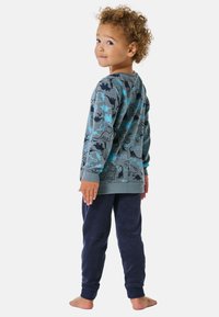 Pyjama-Set für Kinder mit einem grauen Langarmoberteil, das farbenfrohe Dinosauriermuster zeigt, und einer bequemen, weichen Navy-Fleece-Hose.