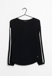 Maglione nero a maniche lunghe con strisce bianche sulle maniche, colletto tondo, appeso a una gruccia nera su uno sfondo bianco.